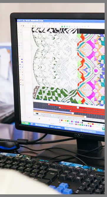 Pattern designer digitizing a lace and jacquard pattern at the group's design desk