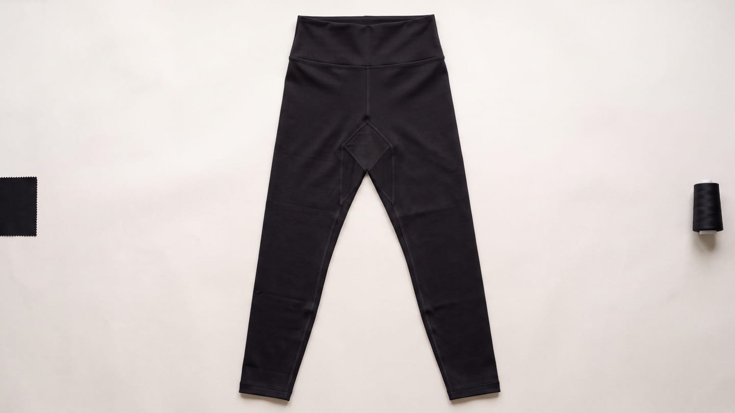 Black high-rise leggings laid flat, full length from waistband to hem, with the diamond gusset visible