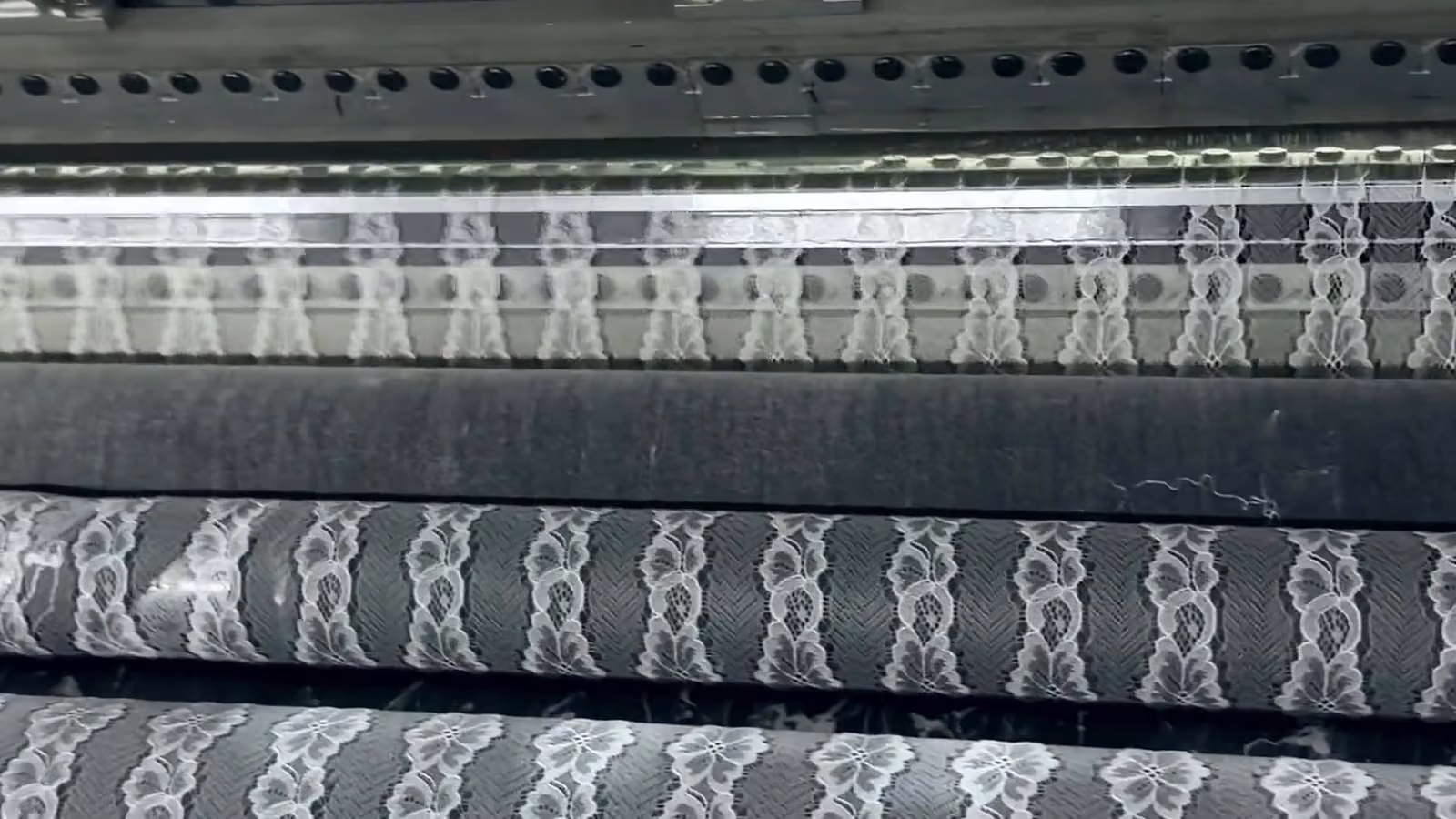 Lace moving through knitting machinery on the floor